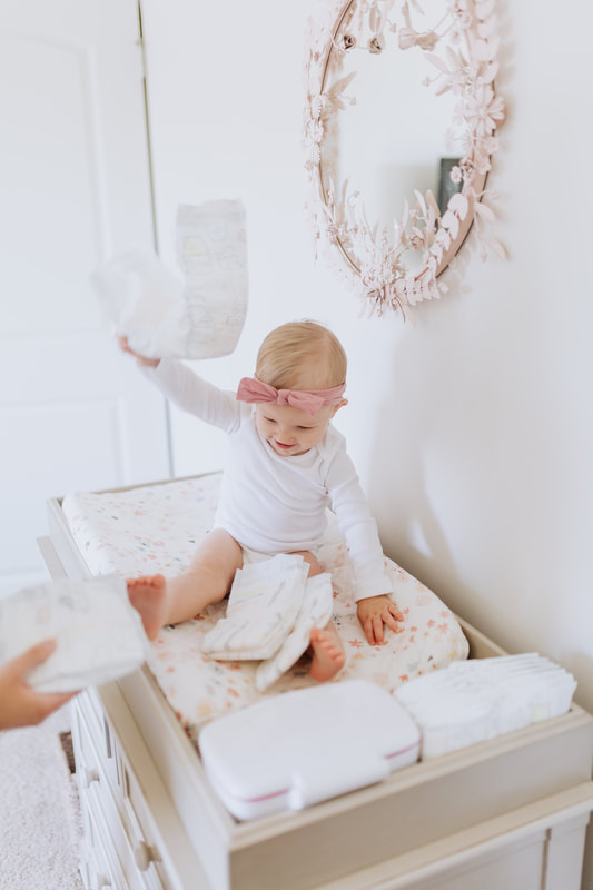 Baby on changing table throwing diapers