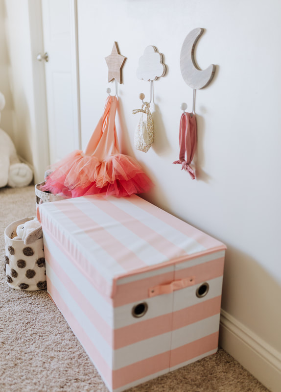 Storage in pretty pink and white baby girl nursery