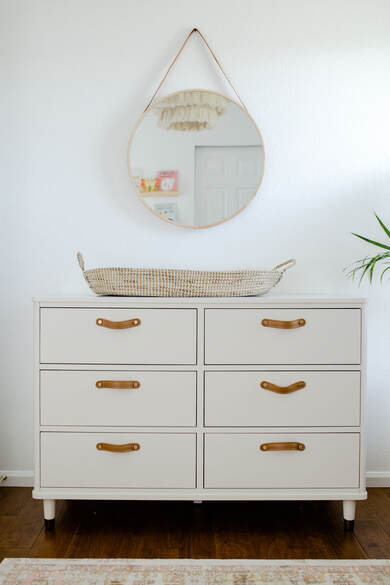 Whiate dresser with leather pulls and roung mirror,YouthfulNest Nursery Design
