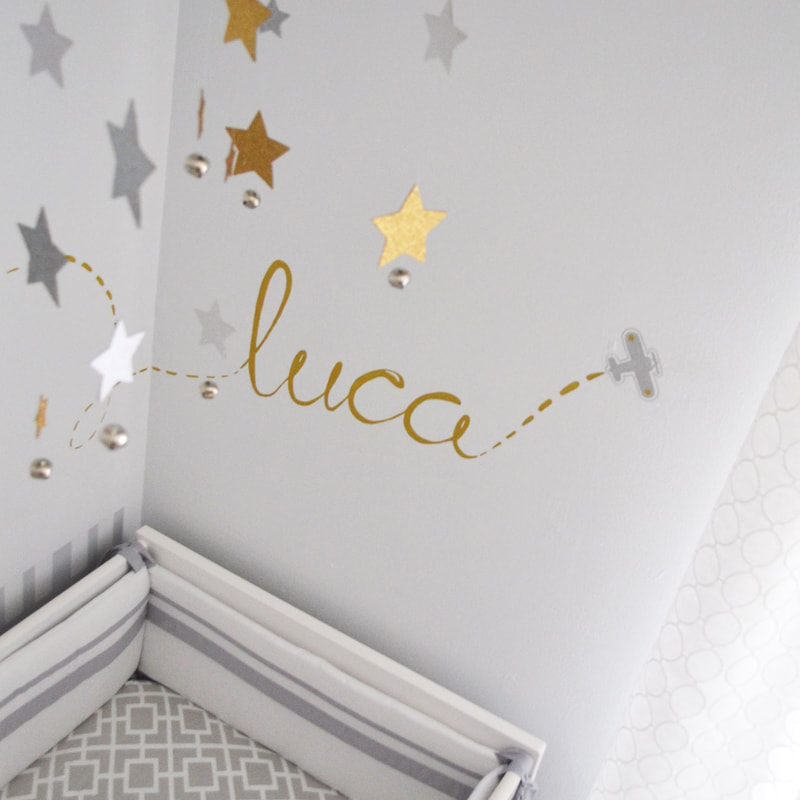 baby nursery with baby name scripted on the wall in gold metallic pen,
